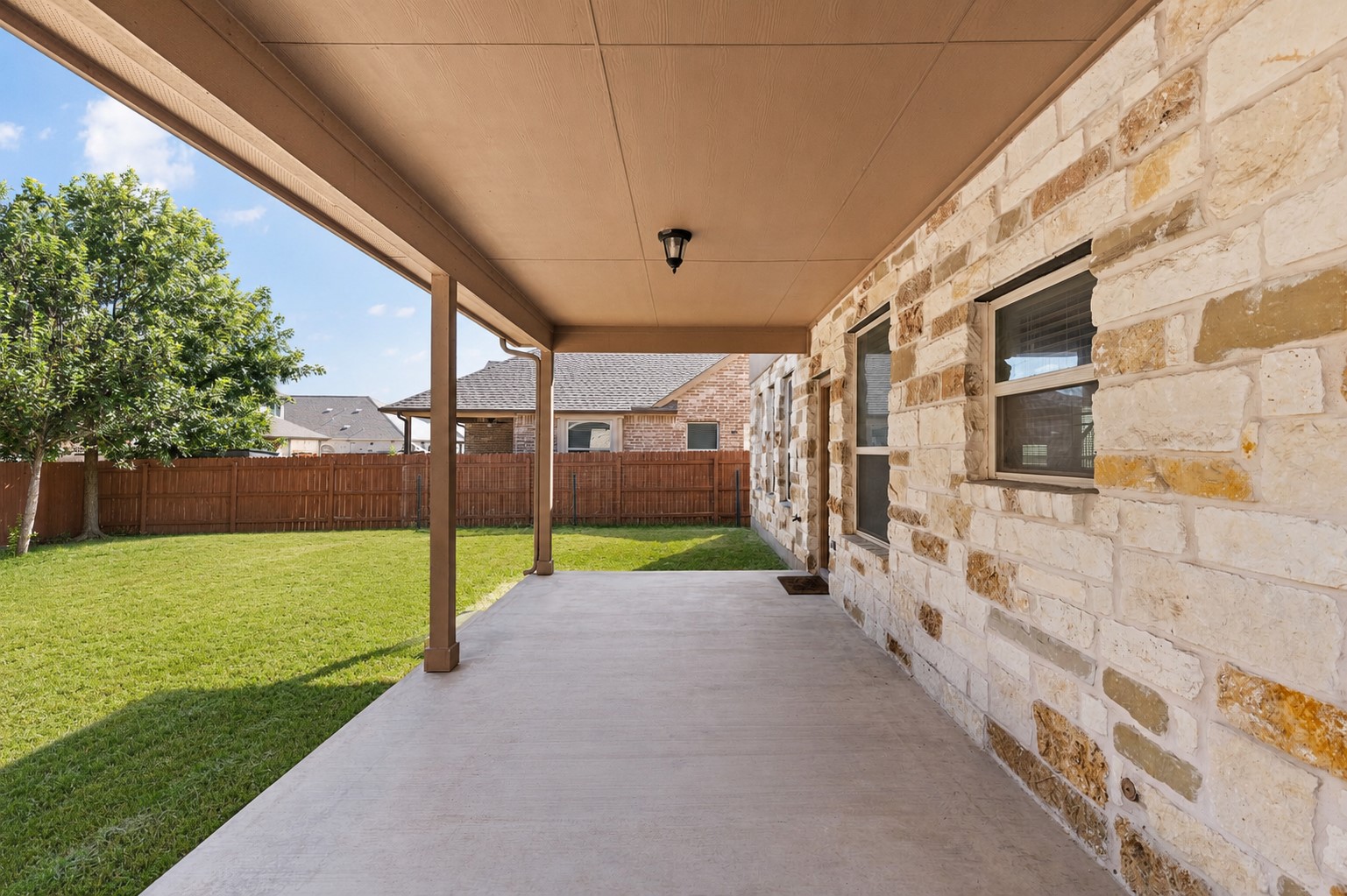 2400 Leonards Pass Leander, TX 78641 - Photo 36 of 40 A spacious covered patio overlooks a generous green lawn, perfect for outdoor leisure.
