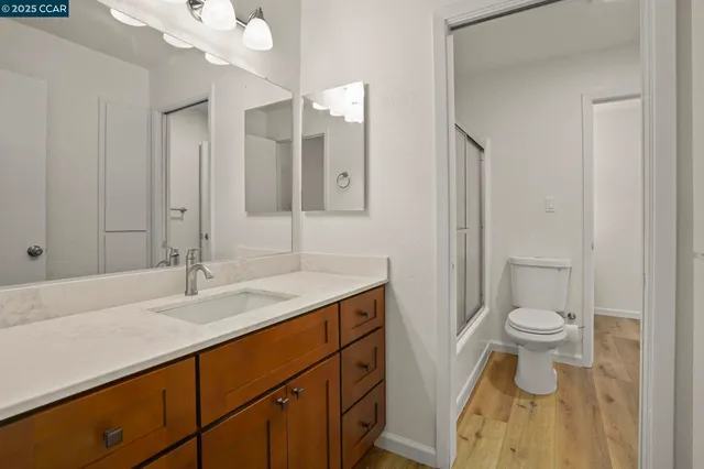 a bathroom with a sink vanity mirror and toilet