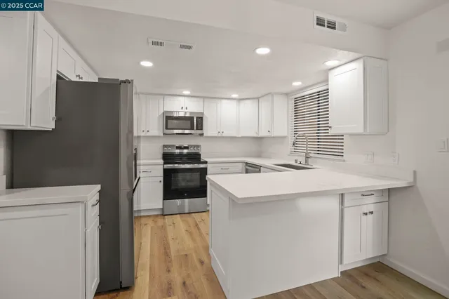 a kitchen with kitchen island a white cabinets and refrigerator