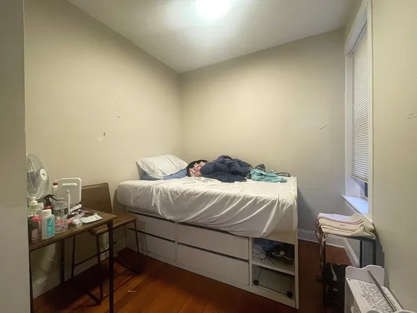 a bedroom with a bed and a dresser in it