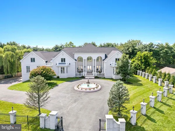 a view of a white house with a big yard and potted plants
