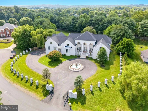 an aerial view of a house with swimming pool a yard and a large pool