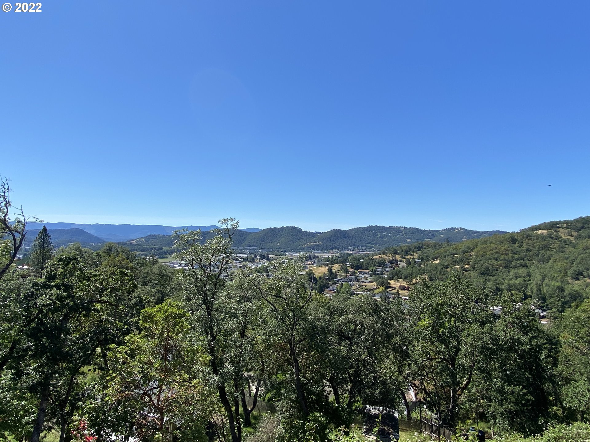 1548 Northeast Rocky Ridge Drive Roseburg, OR 97470 - Photo 2 of 31 a view of a city with lush green forest
