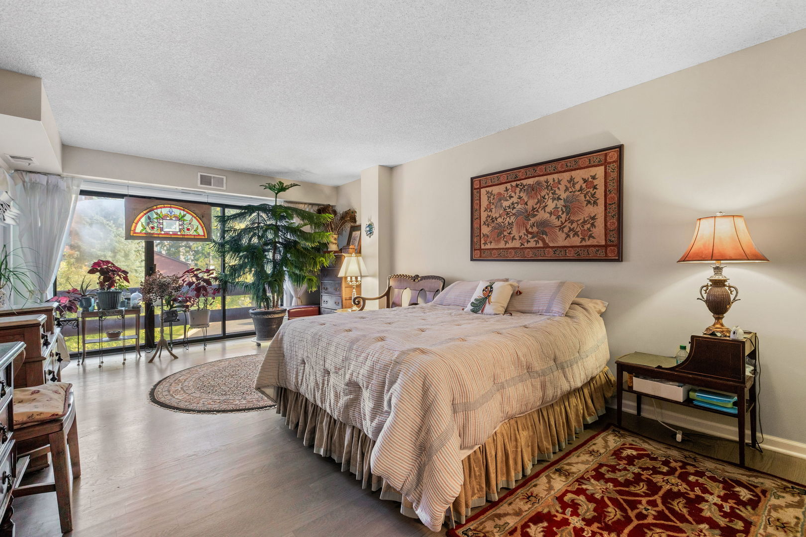 710 Waukegan Road, Unit 201 Glenview, IL 60025 - Photo 11 of 20 a spacious bedroom with a bed a lamp and a large window