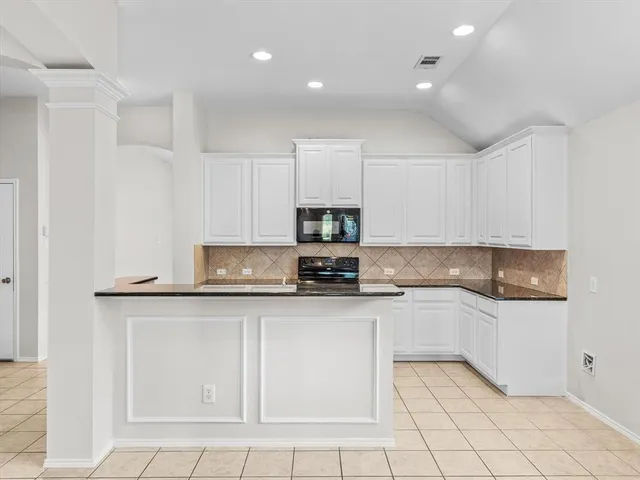 a kitchen with granite countertop white cabinets and white appliances