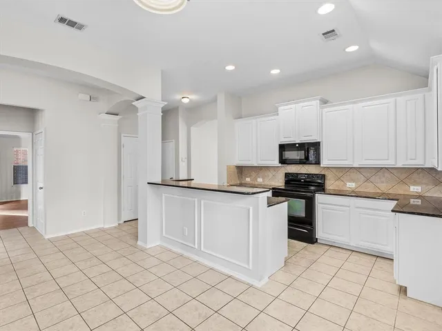 a kitchen with white cabinets a sink and white appliances