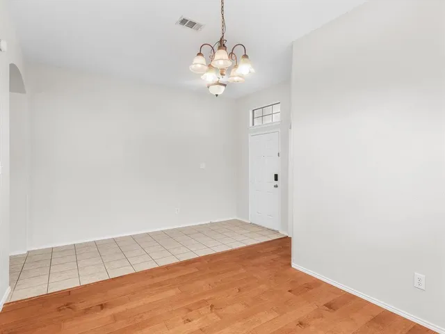a view of a chandelier fan and hardwood floor