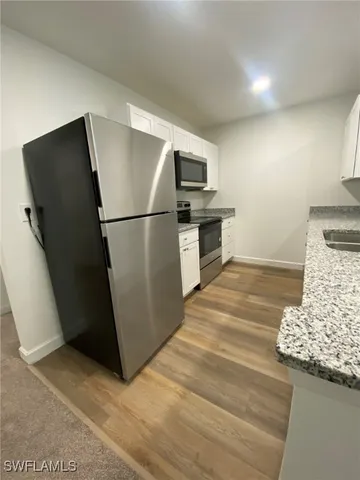 a kitchen with a refrigerator and a stove