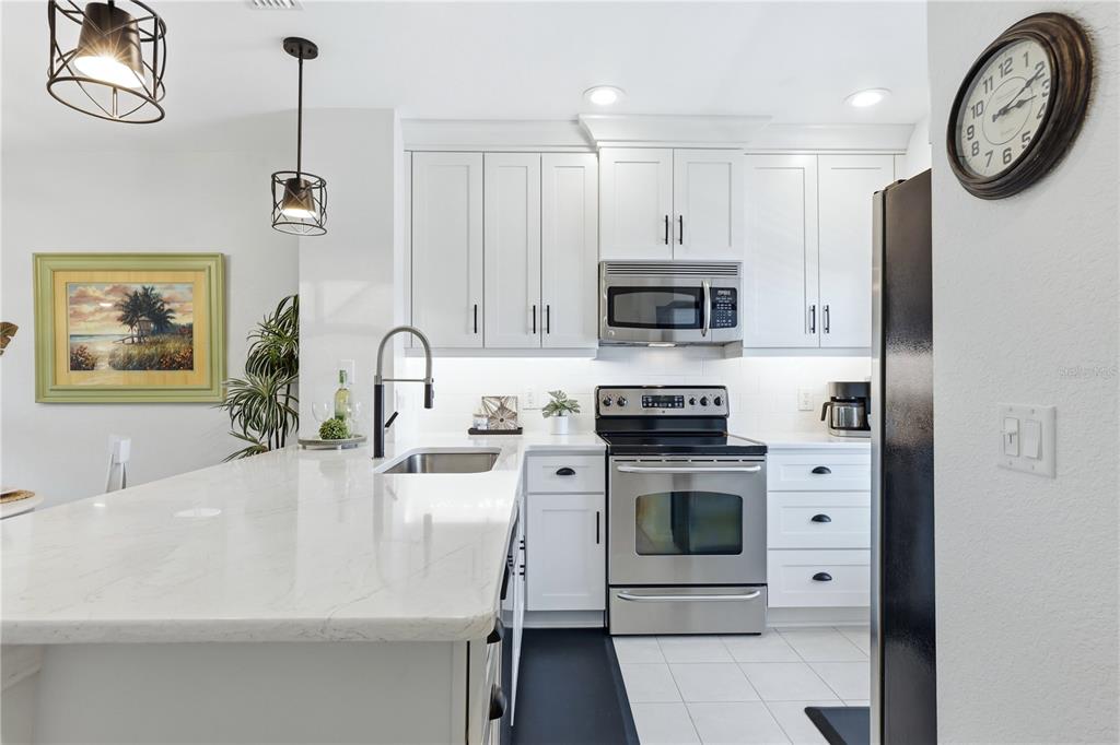 8405 Placida Road, Unit 204 Placida, FL 33946 - Photo 21 of 49 a kitchen with stainless steel appliances a stove a sink a microwave and cabinets