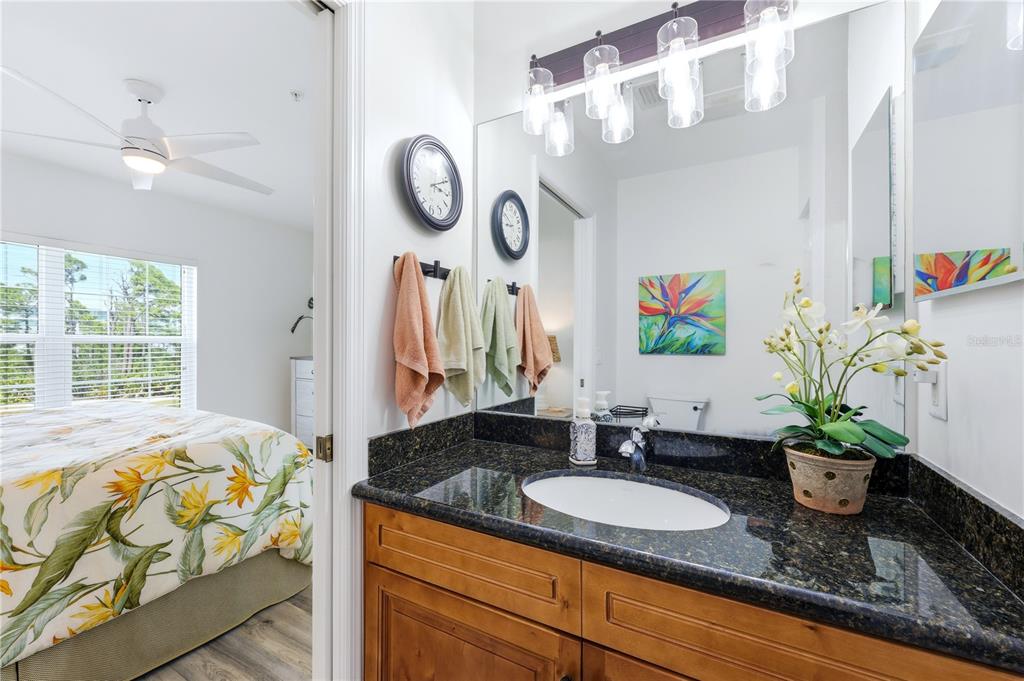 8405 Placida Road, Unit 204 Placida, FL 33946 - Photo 30 of 49 a bathroom with a granite countertop sink a large mirror and a window