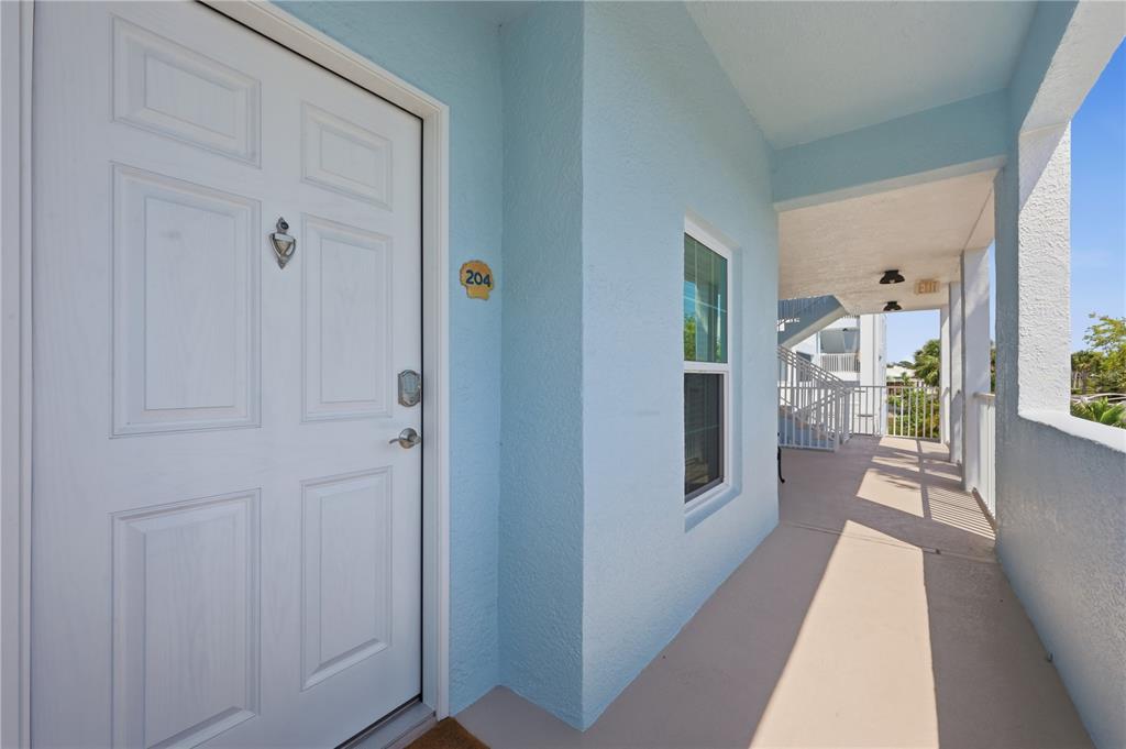 8405 Placida Road, Unit 204 Placida, FL 33946 - Photo 5 of 49 a view of a hallway with wooden floor and a bathroom