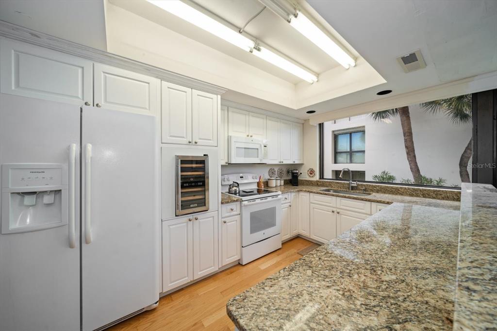50 Coe Road, Unit 311 Belleair, FL 33756 - Photo 10 of 53 a kitchen with stainless steel appliances granite countertop a refrigerator a stove and a sink