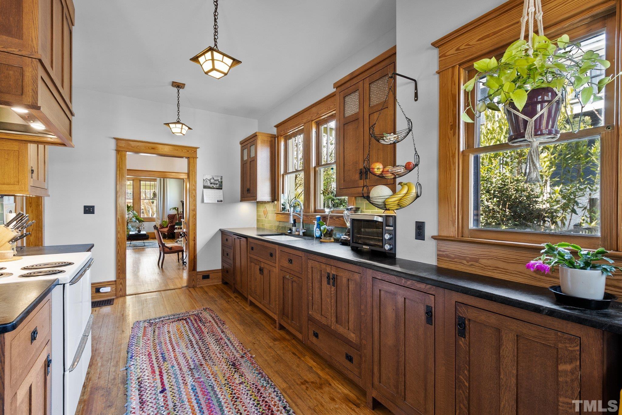 543 East Jones Street Raleigh, NC 27601 - Photo 14 of 31 a kitchen with stainless steel appliances wooden floor window and cabinets