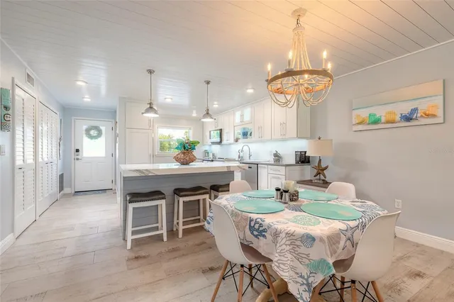 a kitchen with stainless steel appliances kitchen island a stove a table and chairs in it