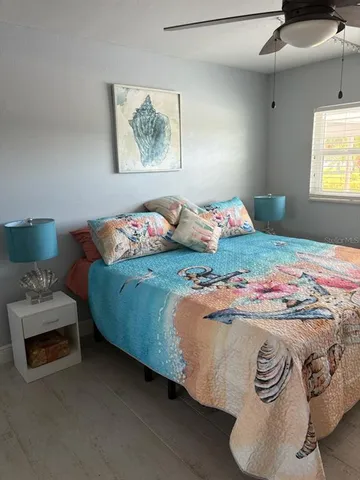 a living room with furniture a flat screen tv and a large window