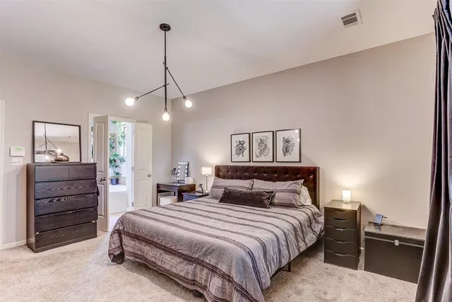 a bedroom with a bed a dresser and painting on the wall