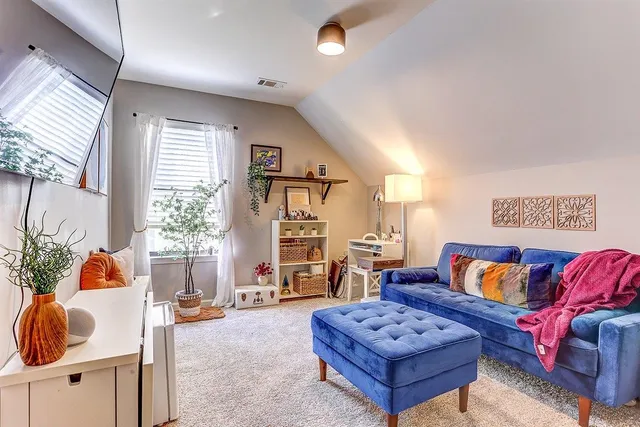 a living room with furniture and a potted plant