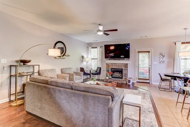 a living room with furniture a flat screen tv and a fireplace