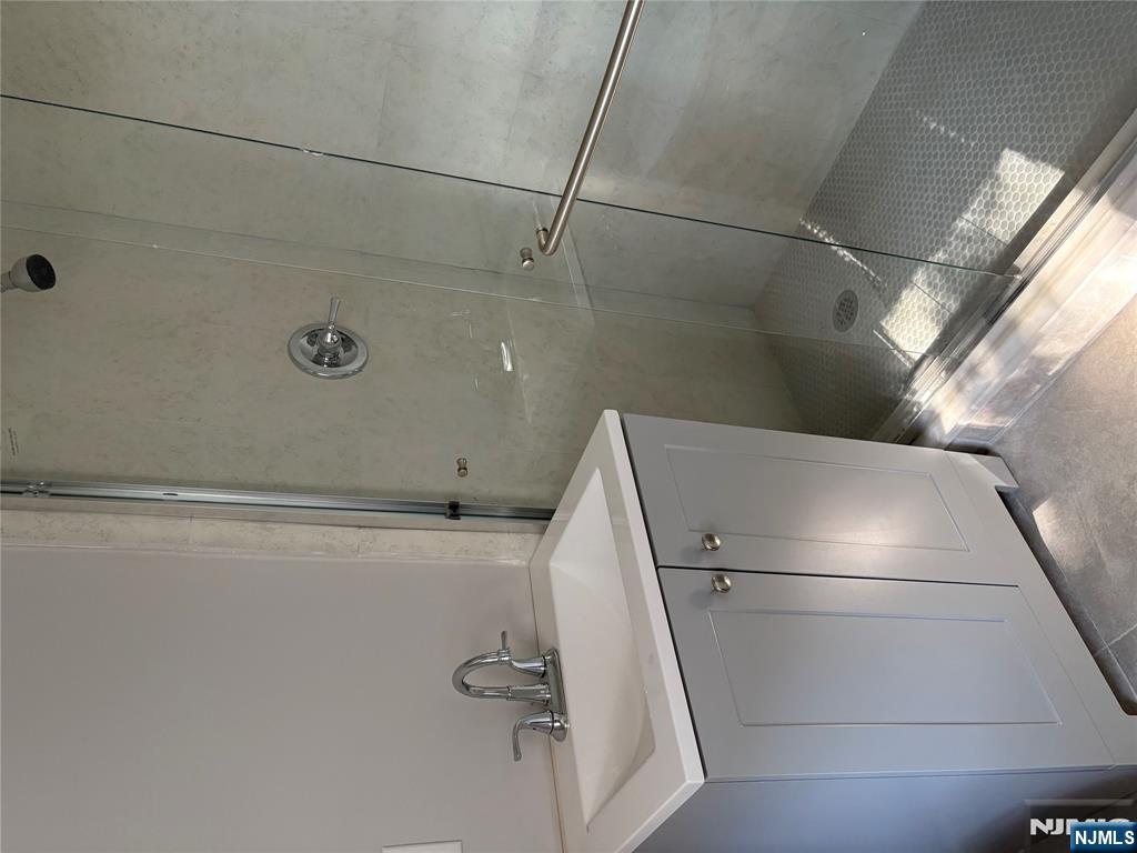 233 Myrtle Avenue, Unit A Fort Lee, NJ 07024 - Photo 4 of 11 a bathroom with a sink a toilet and shower