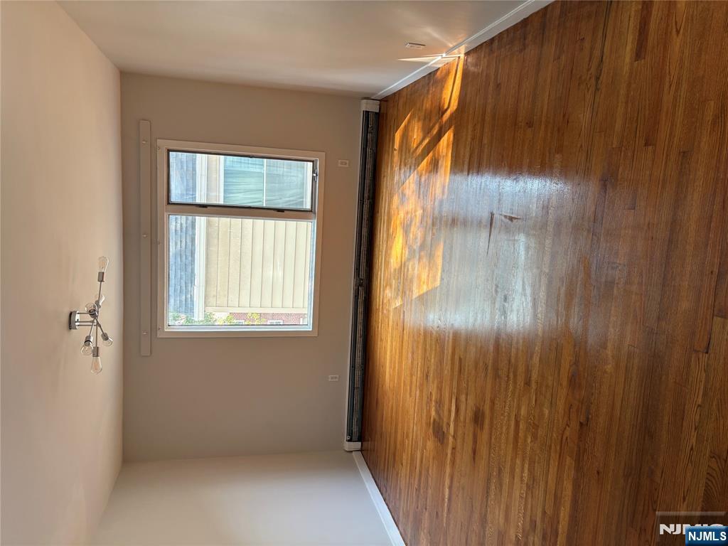 233 Myrtle Avenue, Unit A Fort Lee, NJ 07024 - Photo 5 of 11 an empty room with wooden floor and windows