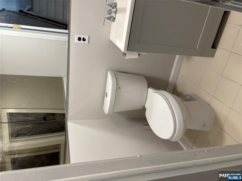 233 Myrtle Avenue, Unit A Fort Lee, NJ 07024 - Photo 7 of 11 a bathroom with a toilet sink and mirror