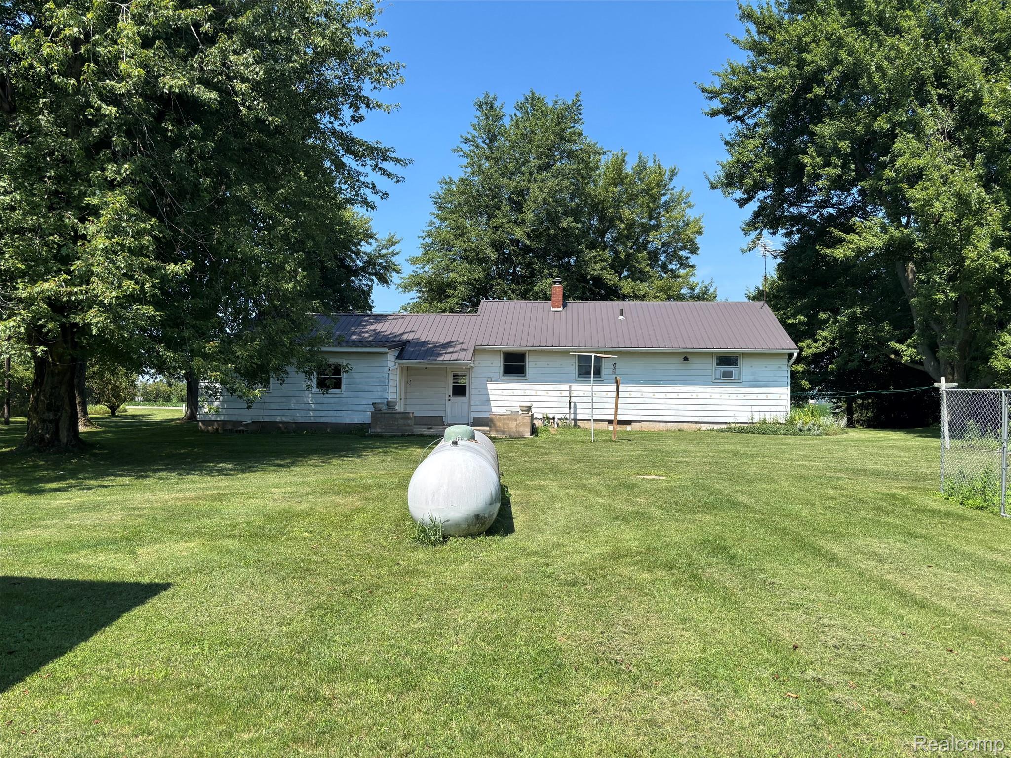 8531 South Waldron Road Pittsford, MI 49271 - Photo 23 of 40 Expansive grassy yard with mature trees and a chain-link fence