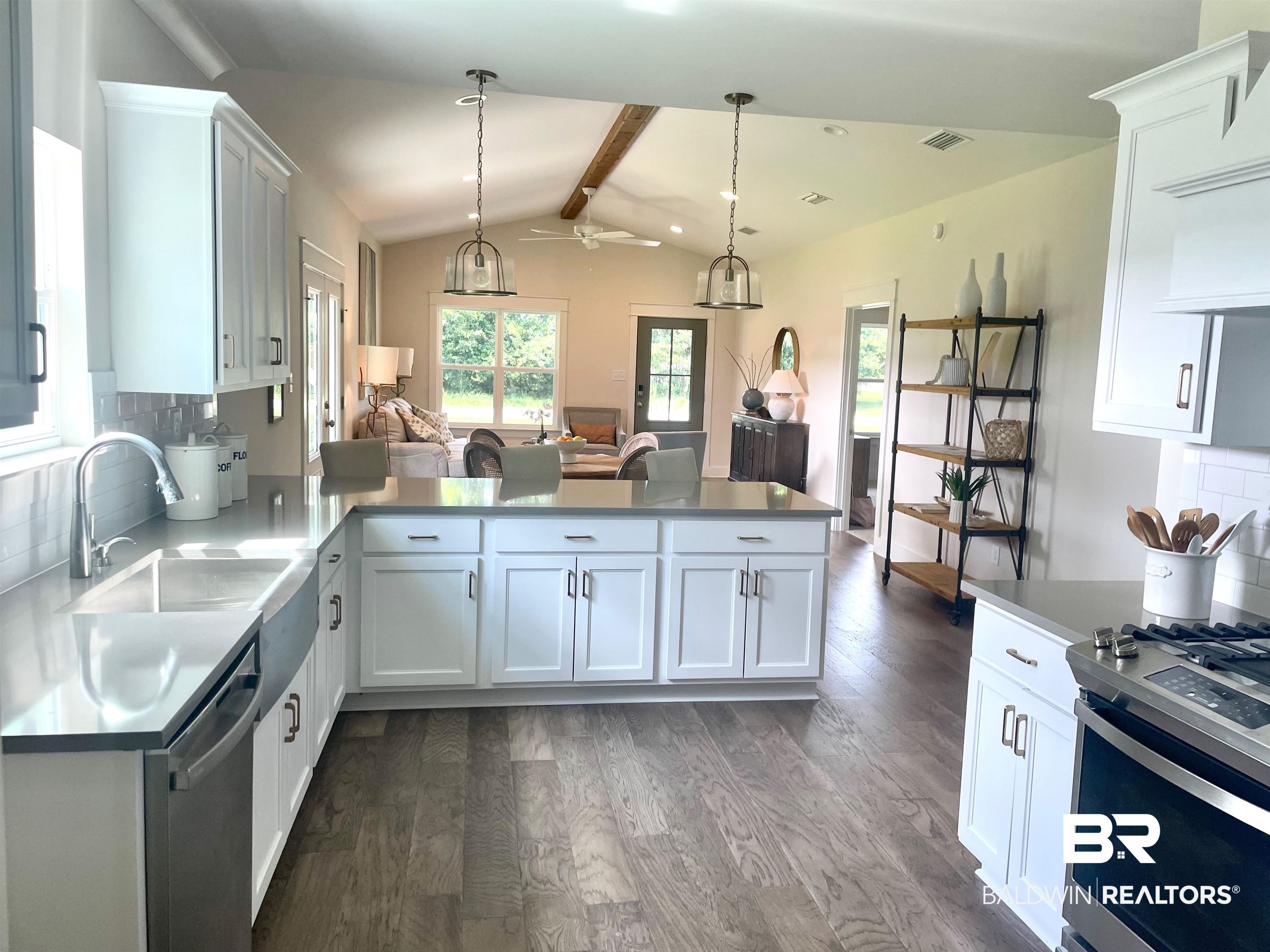 14710 Camelia Street Magnolia Springs, AL 36555 - Photo 5 of 23 Kitchen featuring vaulted ceiling with beams, backsplash, sink, dark wood-type flooring, and white cabinetry