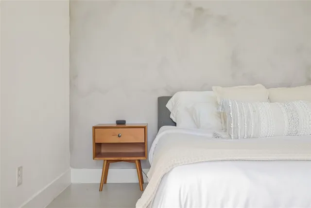 a bed sitting in a bedroom next to a window