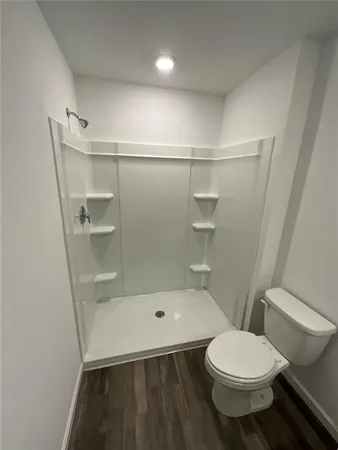 a bathroom with a toilet and a shower