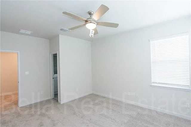 an empty room with windows and fan