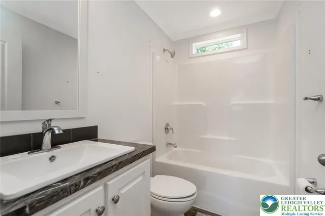 a bathroom with a granite countertop sink a toilet and shower
