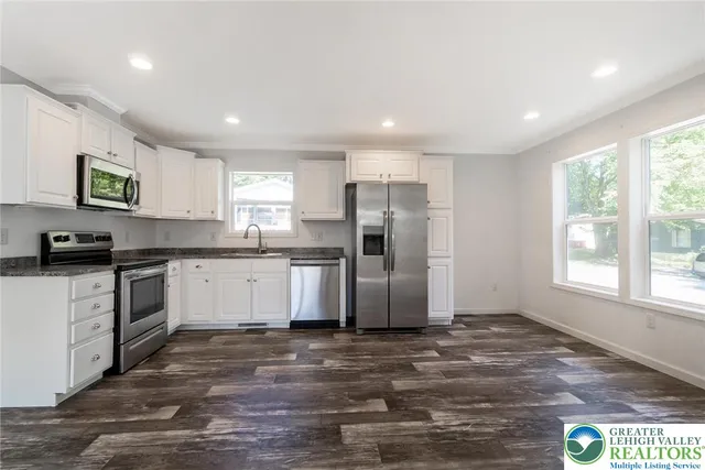 a kitchen with a refrigerator and a stove top oven
