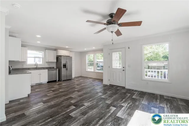 a view of empty room with wooden floor and window