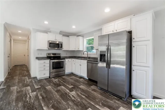 a kitchen with kitchen island a white cabinets and refrigerator