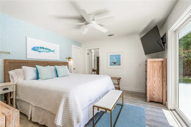 a bedroom with a bed a flat screen tv and a large window