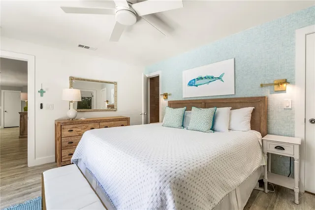 a bedroom with a large bed and a chandelier