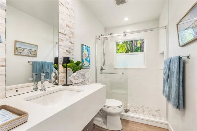 a bathroom with a double vanity sink toilet and shower