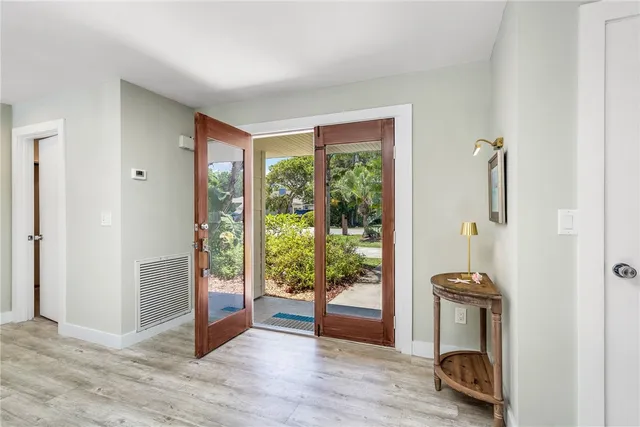 a view of a hallway with wooden floor and windows