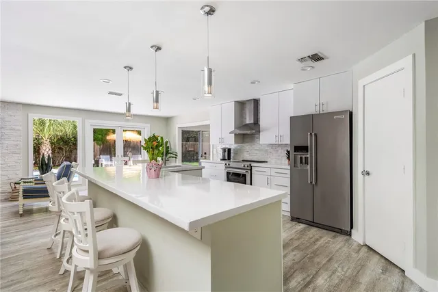 a kitchen with refrigerator cabinets dining table and chairs