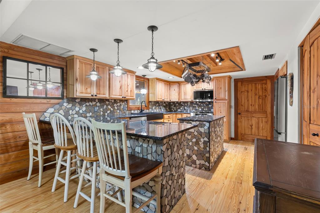 809 Cardinal Avenue Palm Harbor, FL 34683 - Photo 14 of 66 a open kitchen with stainless steel appliances granite countertop a stove and a wooden floors