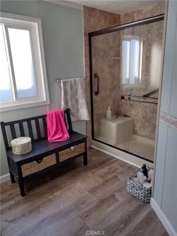 a bedroom with a bed and a window with wooden floor