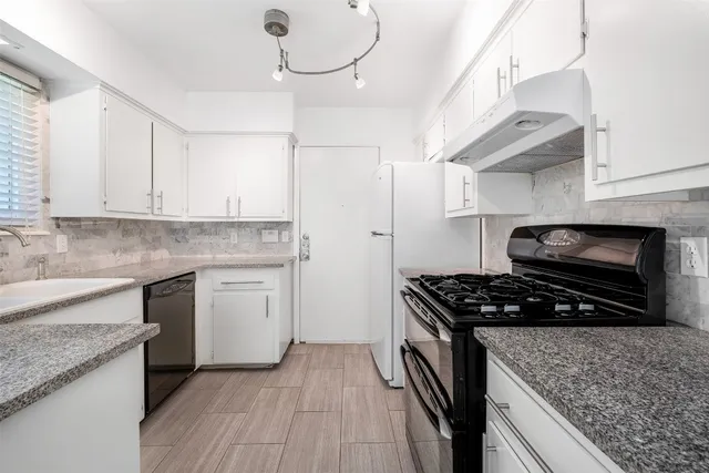 a kitchen with stainless steel appliances granite countertop a sink stove and cabinets