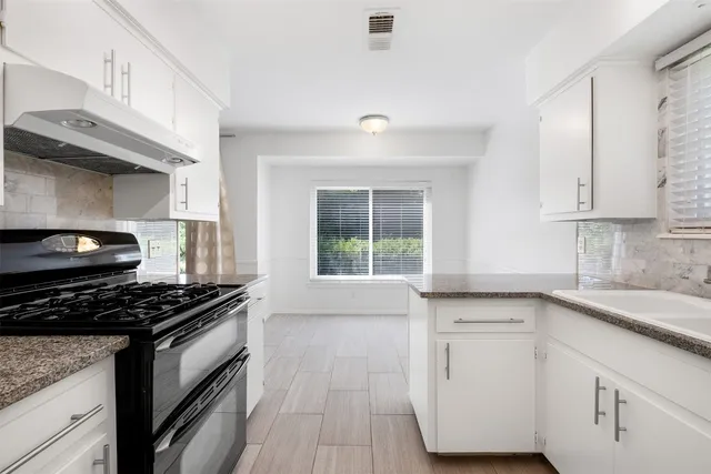 a kitchen with granite countertop a stove and a sink