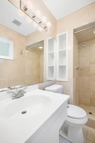 a bathroom with a sink a toilet and shower