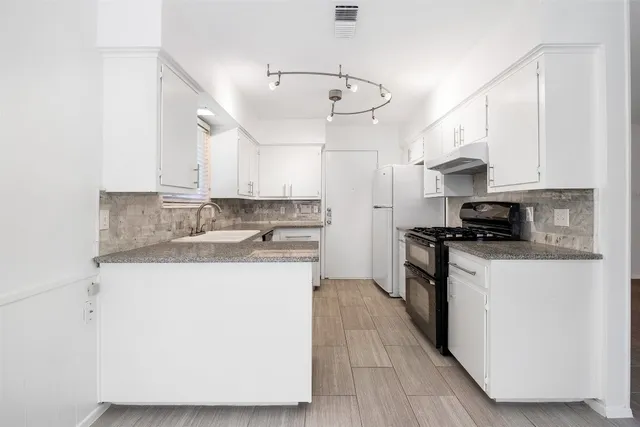 a kitchen with kitchen island granite countertop a sink a counter top space and cabinets