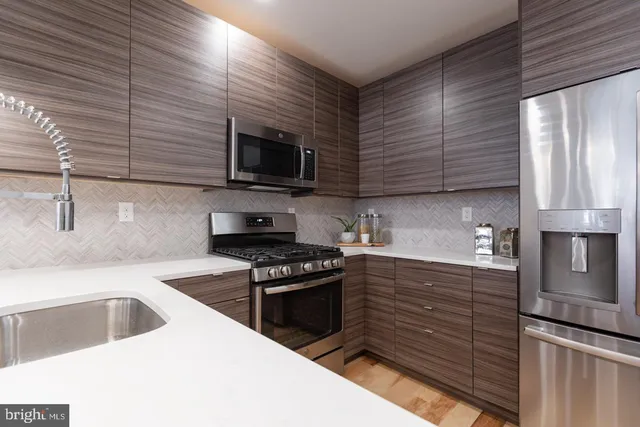 a kitchen with granite countertop stainless steel appliances a stove sink and microwave