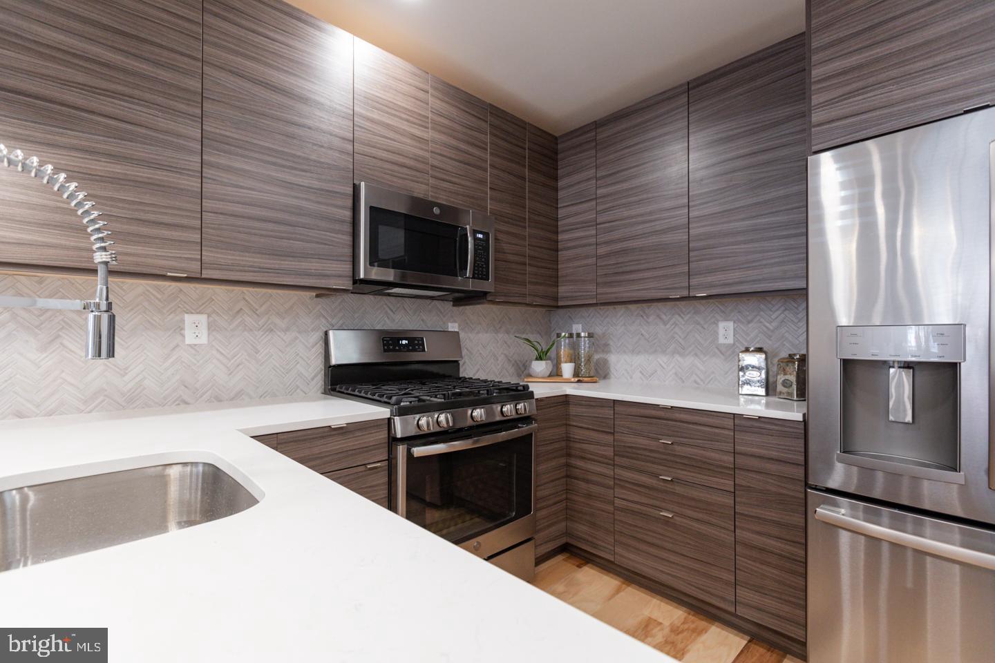 1322 Hope Street, Unit A Philadelphia, PA 19122 - Photo 16 of 30 a kitchen with granite countertop stainless steel appliances a stove sink and microwave