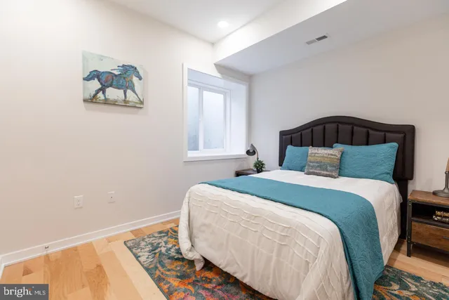 a bedroom with a bed and a painting on the wall