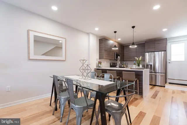 a kitchen with stainless steel appliances kitchen island a table and chairs in it