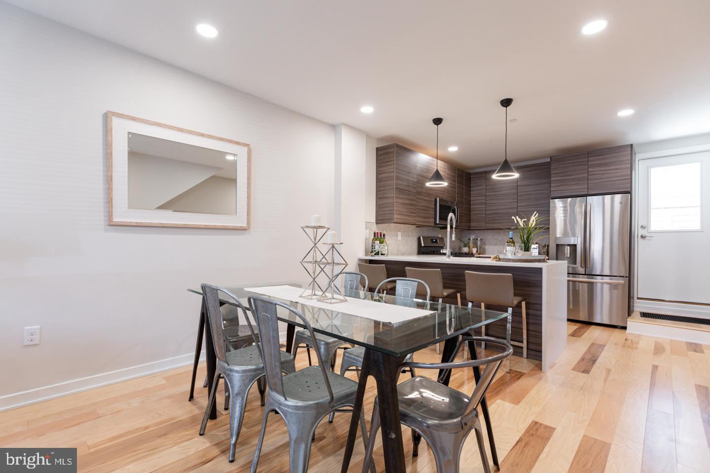 1322 Hope Street, Unit A Philadelphia, PA 19122 - Photo 7 of 30 a kitchen with stainless steel appliances kitchen island a table and chairs in it
